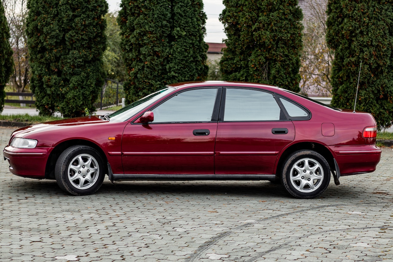 Red Sedan Parked on Pavement | Kids Car Donations