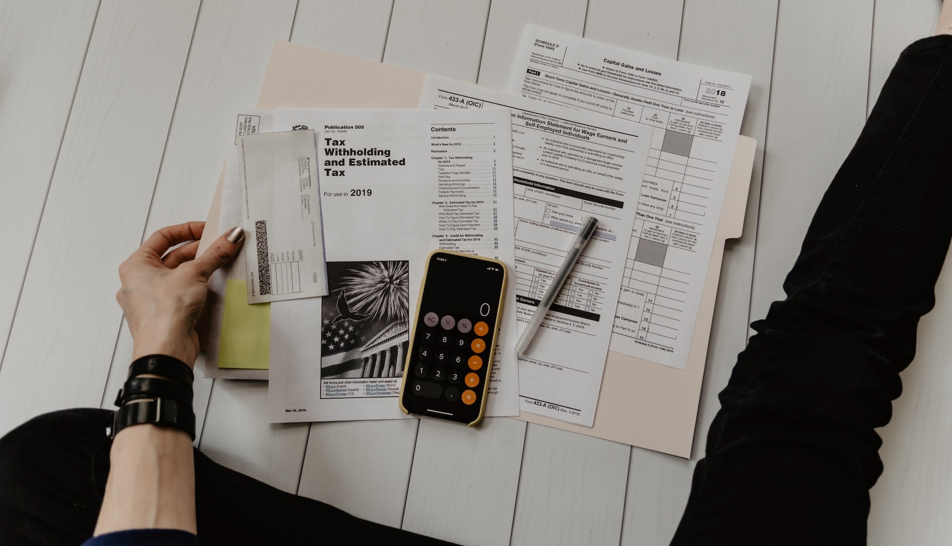 person holding paper near pen and calculator photo | Kids Car Donations