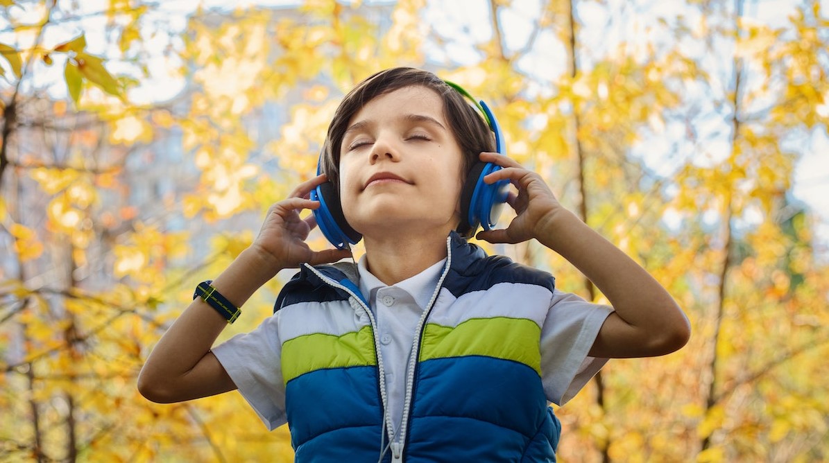 Photo of a Boy Listening in Headphones | Kids Car Donations