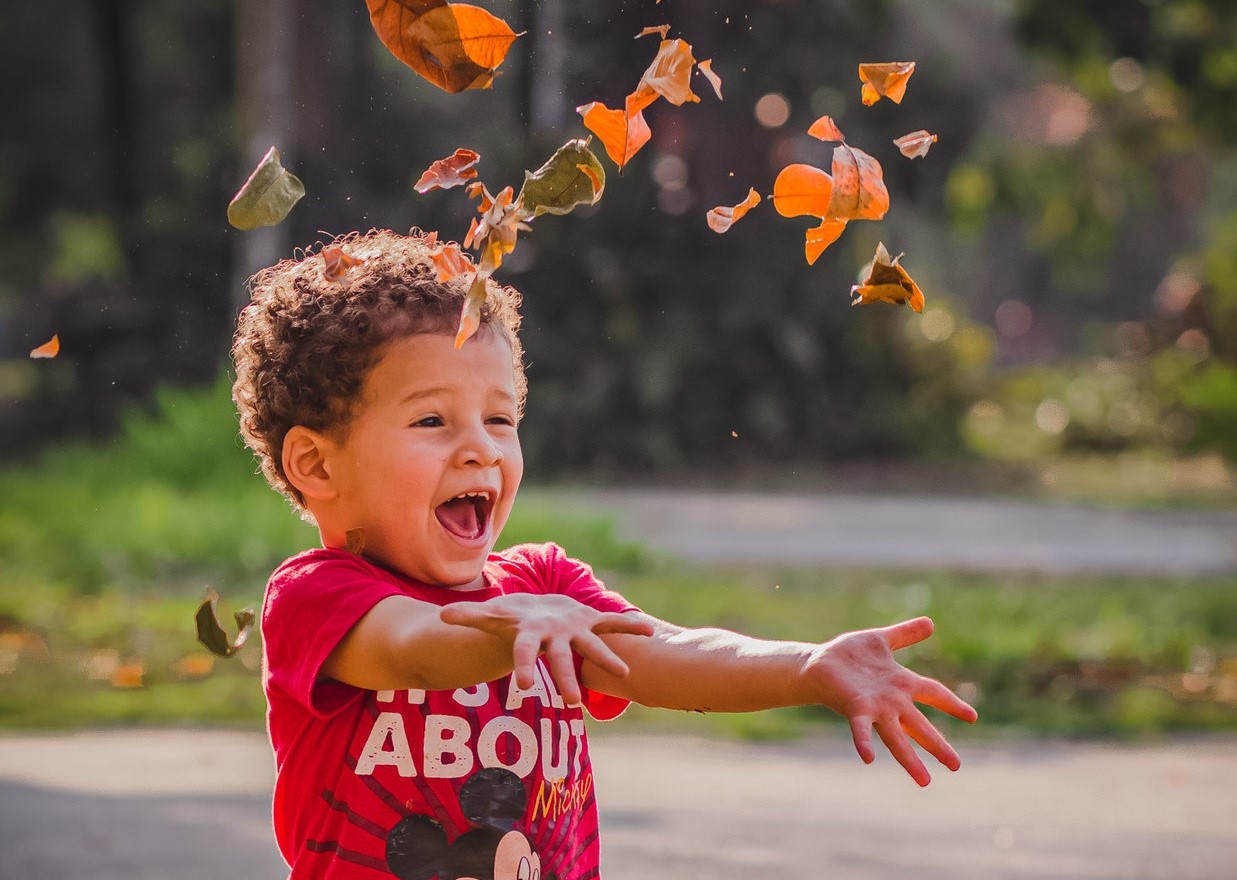 Kid Enjoying the Fallen Leaves | Kids Car Donations