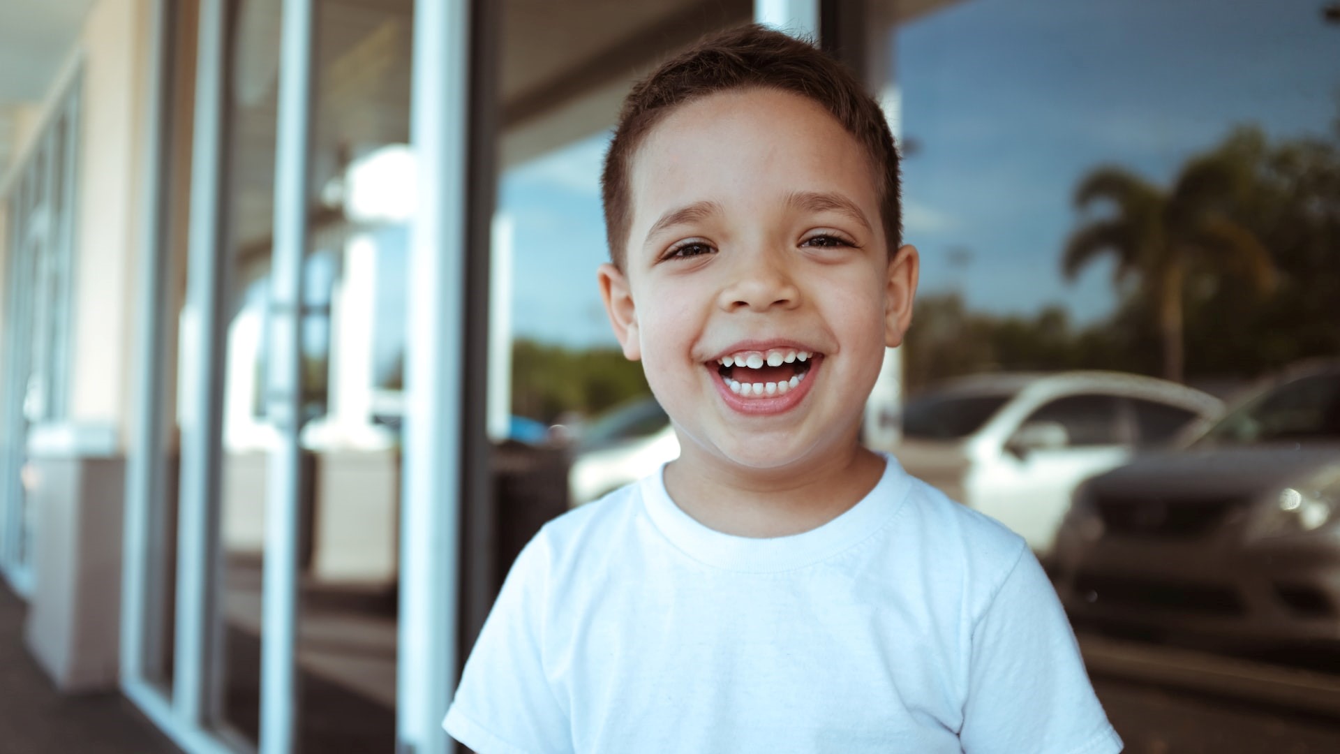 Boy wearing a white shirt smiling | Kids Car Donations