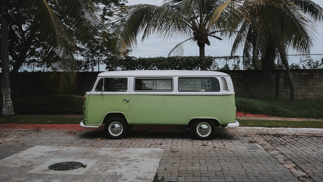 Green volkswagen van parked near a coconut tree | Kids Car Donations