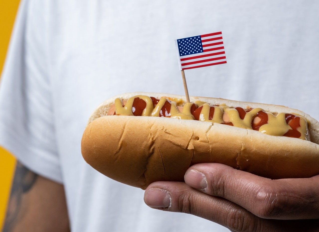 Person Holding a Hotdog with the US Flag | Kids Car Donations