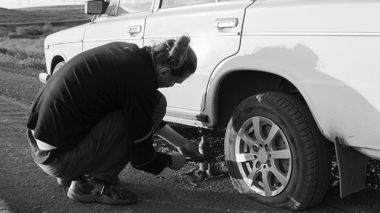Man fixing his car tire | Kids Car Donations