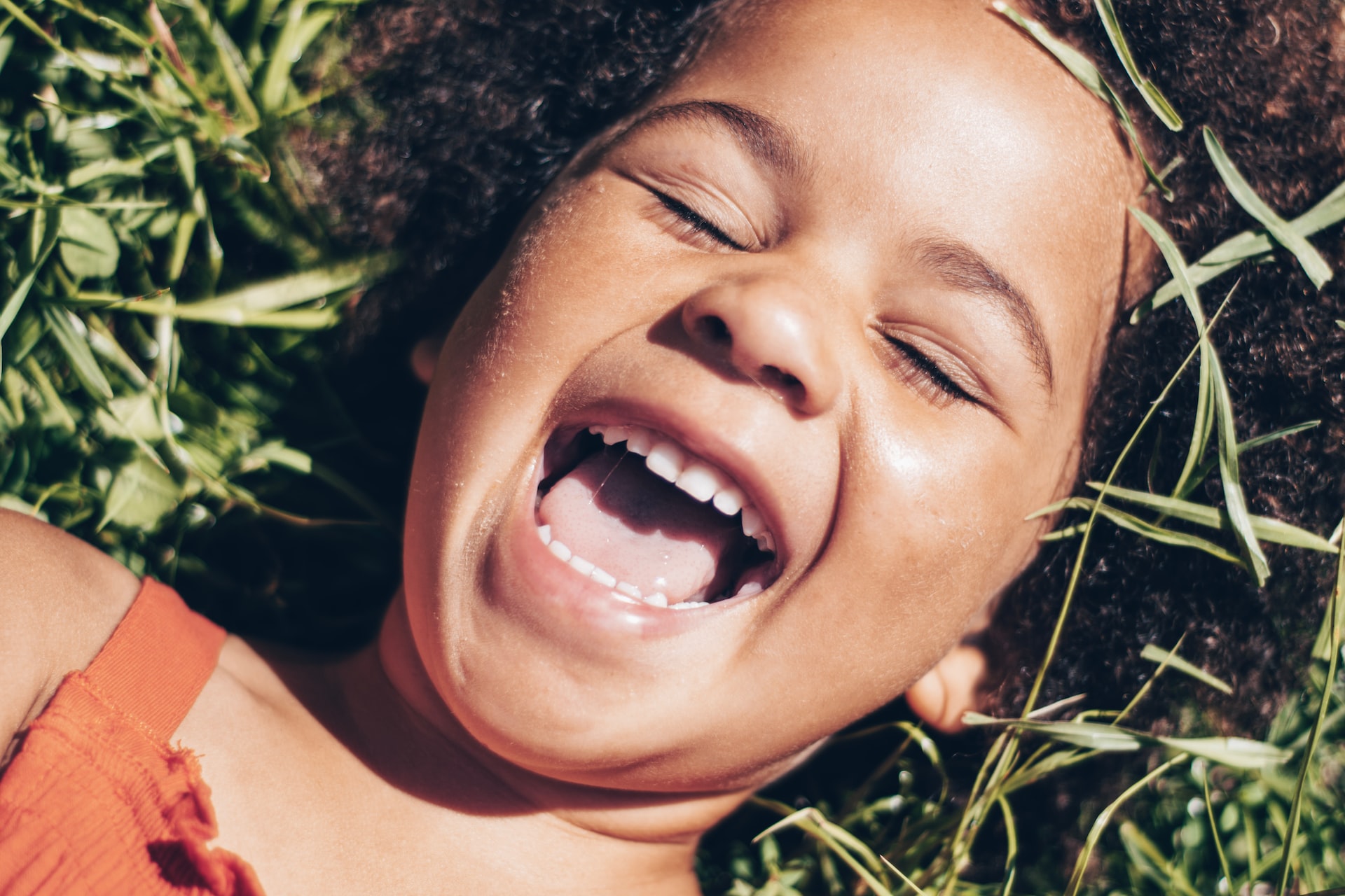 Smiling Girl Lying on The Grass | Kids Car Donations