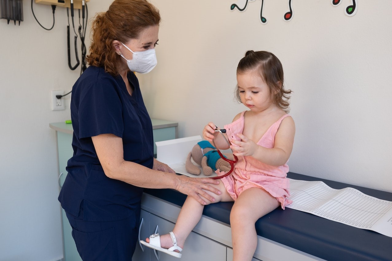 Woman in Blue Shirt Holding Girl in Pink Dress | Kids Car Donations