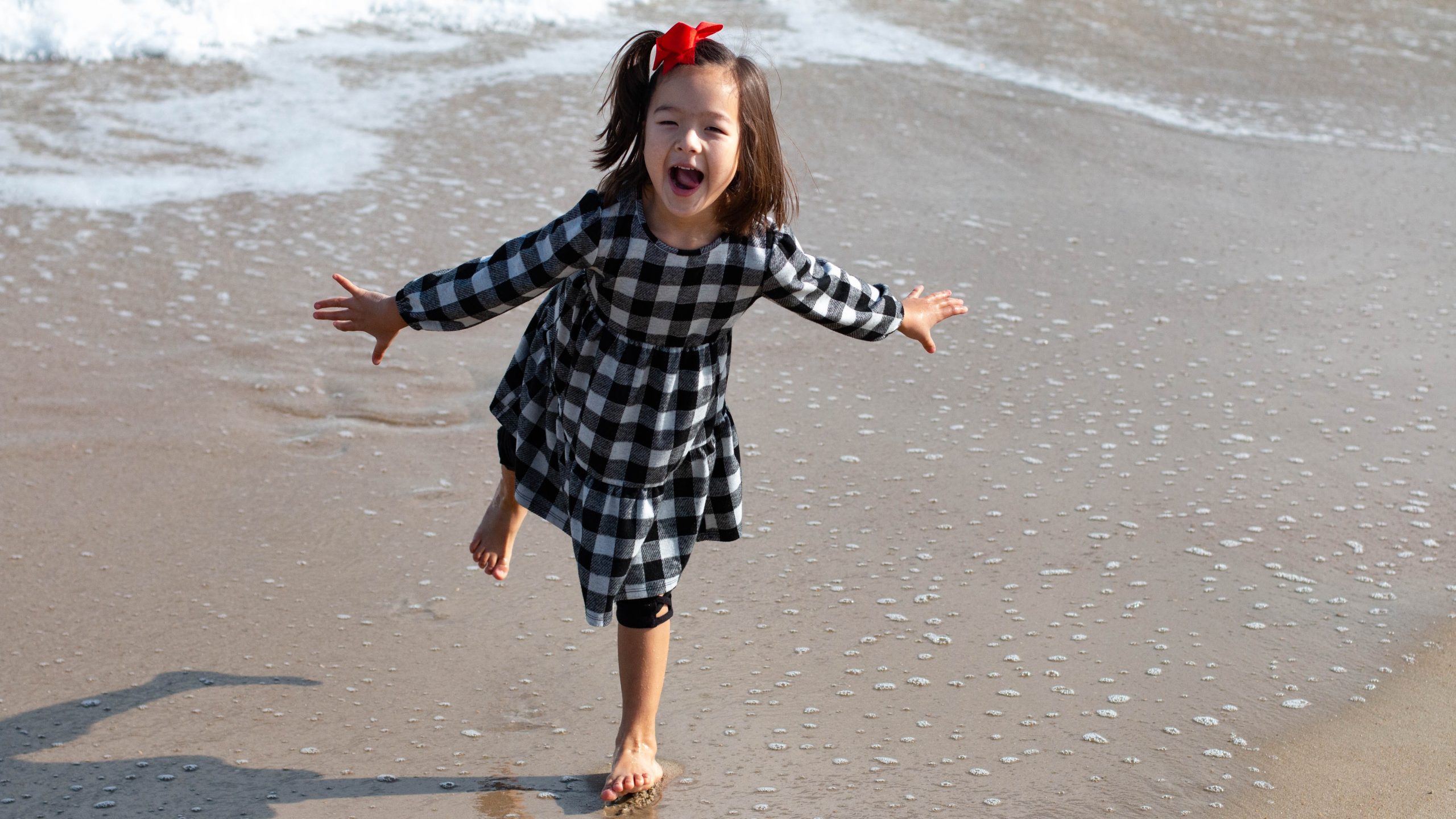Girl in Black and White Plaid Dress on the Beach | Kids Car Donations