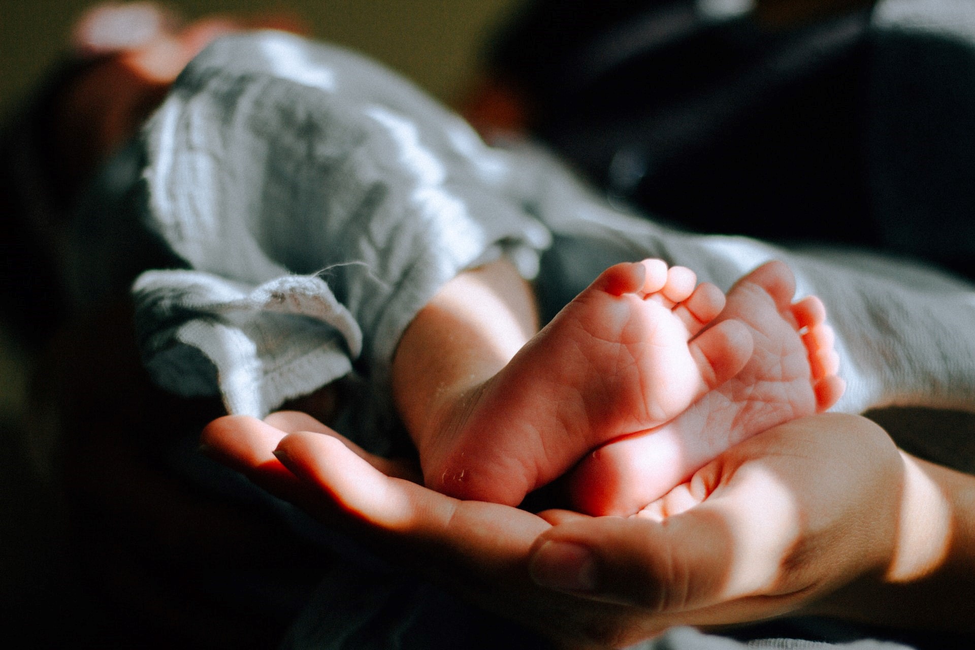 person holding baby feet photo | Kids Car Donations