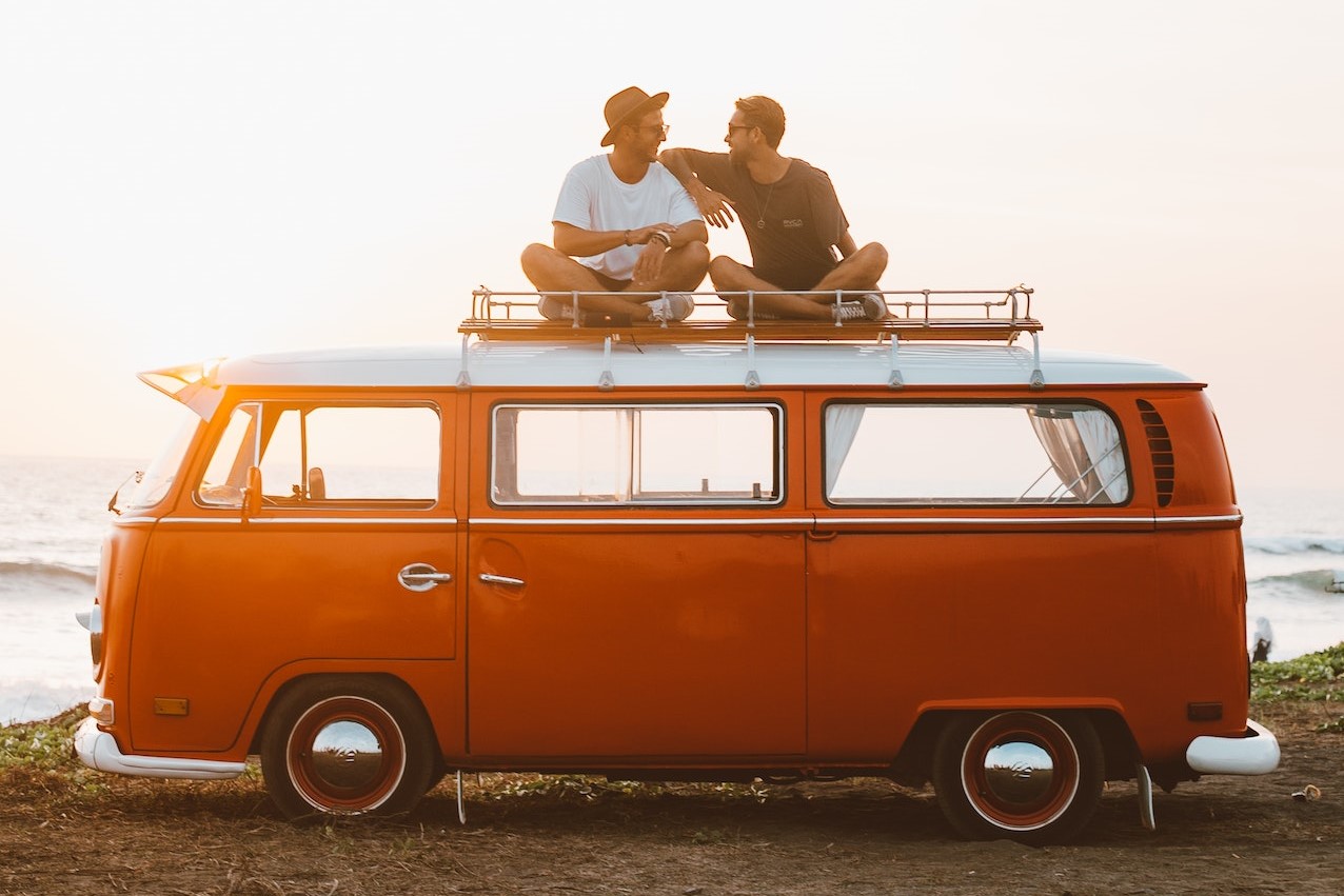 Happy friends on camper van roof | Kids Car Donations