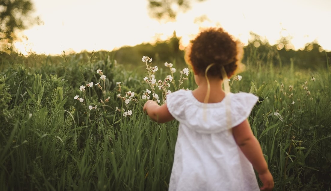 Girl Standing Beside White Flower Field | Kids Car Donations