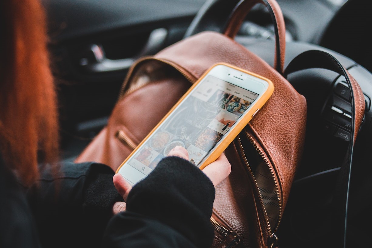 Female driver using smartphone in car | Kids Car Donations