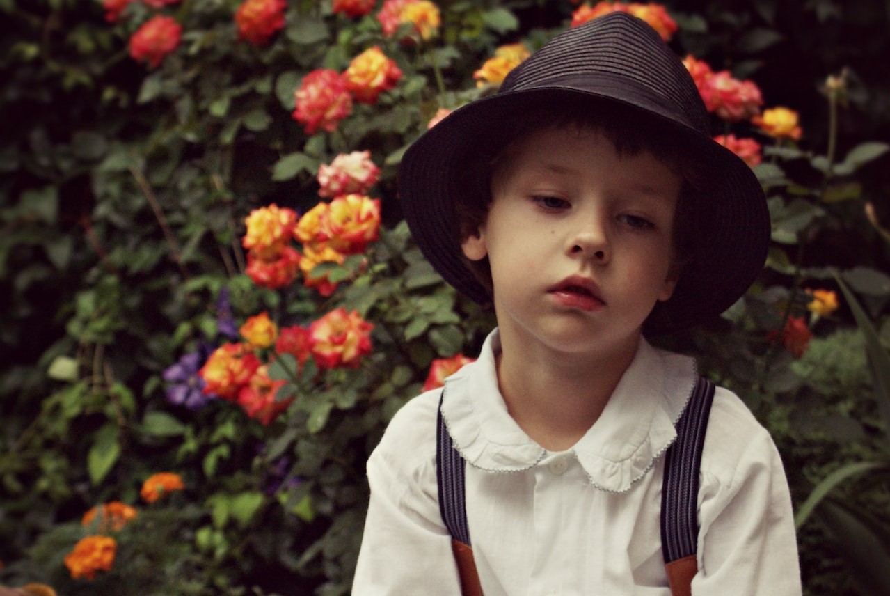 Sad Child sitting on an Old Suitcase | Kids Car Donations