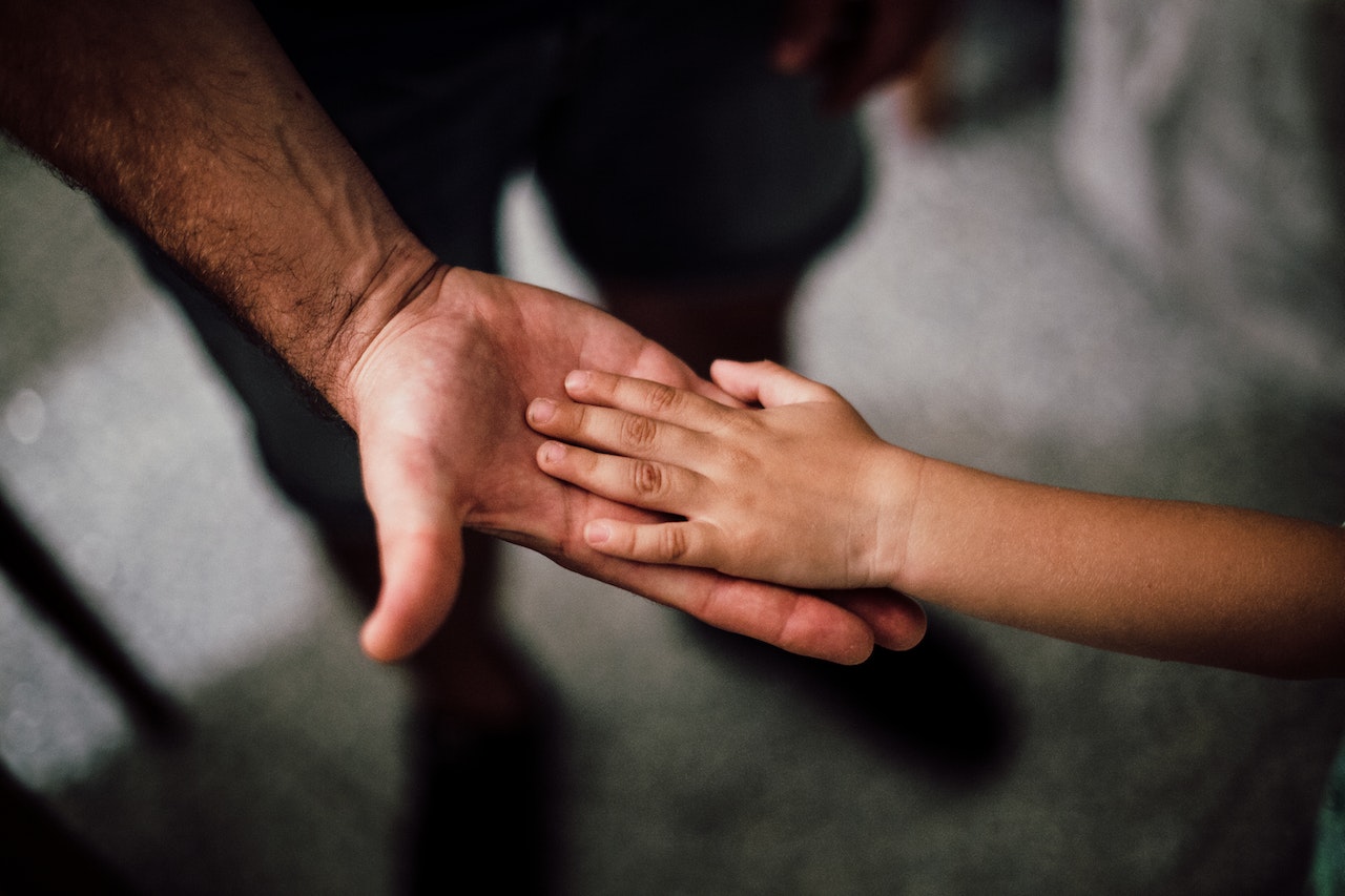 man holding a childs hand | Kids Car Donations