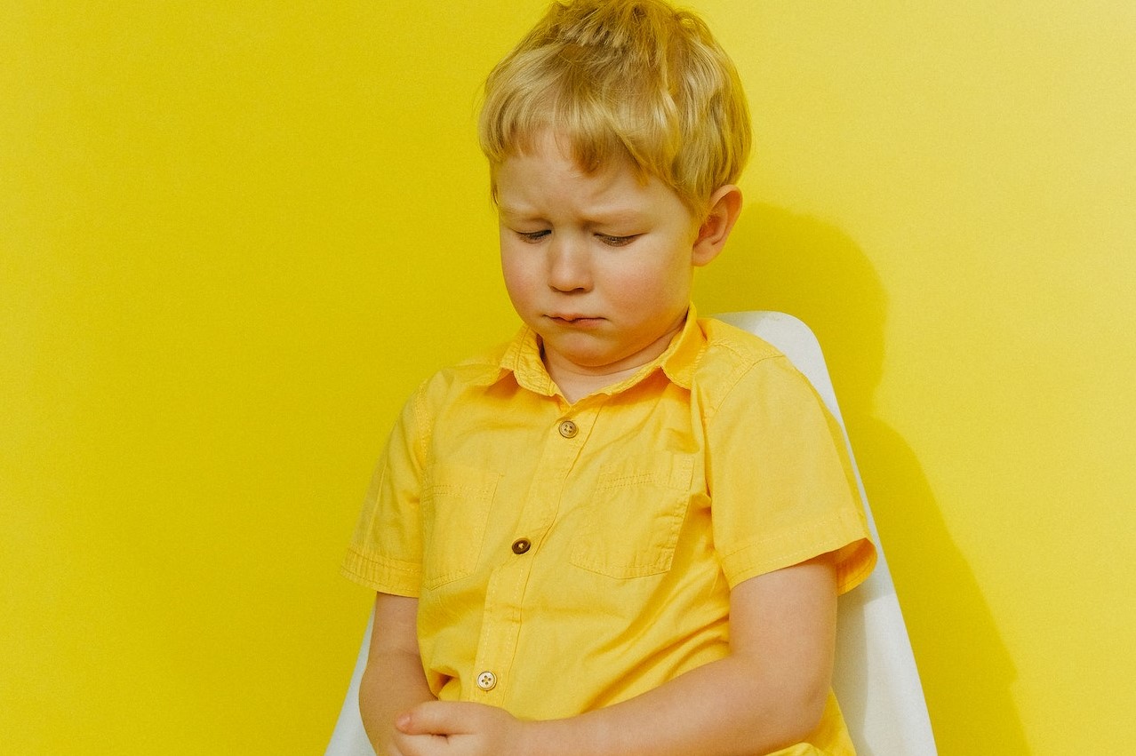 Sad Child sitting on a White Chair | Kids Car Donations