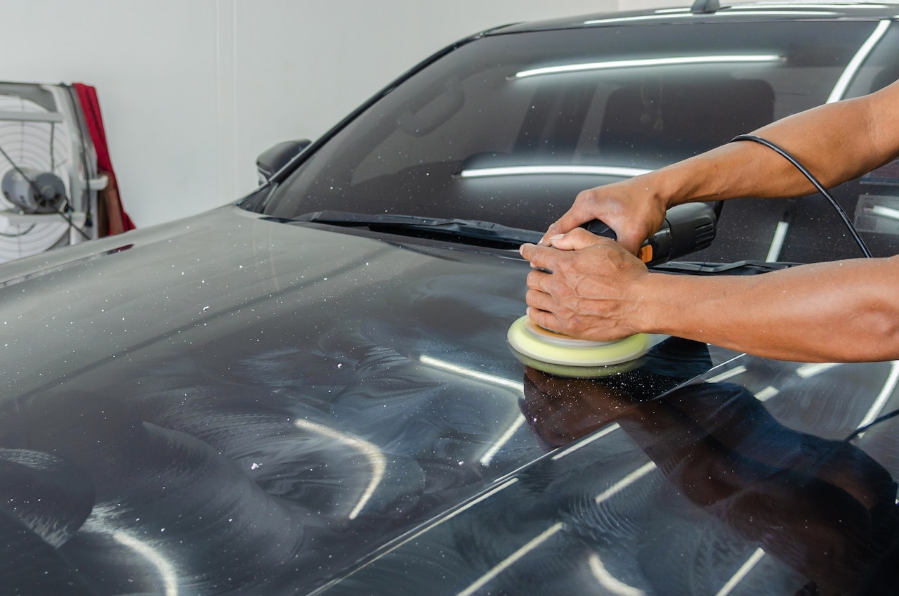 A Person Polishing the Black Car | Kids Car Donations