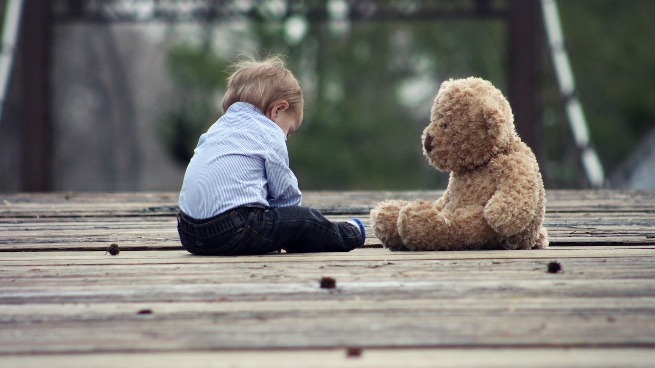 Boy sitting with a brown bear | Kids Car Donations