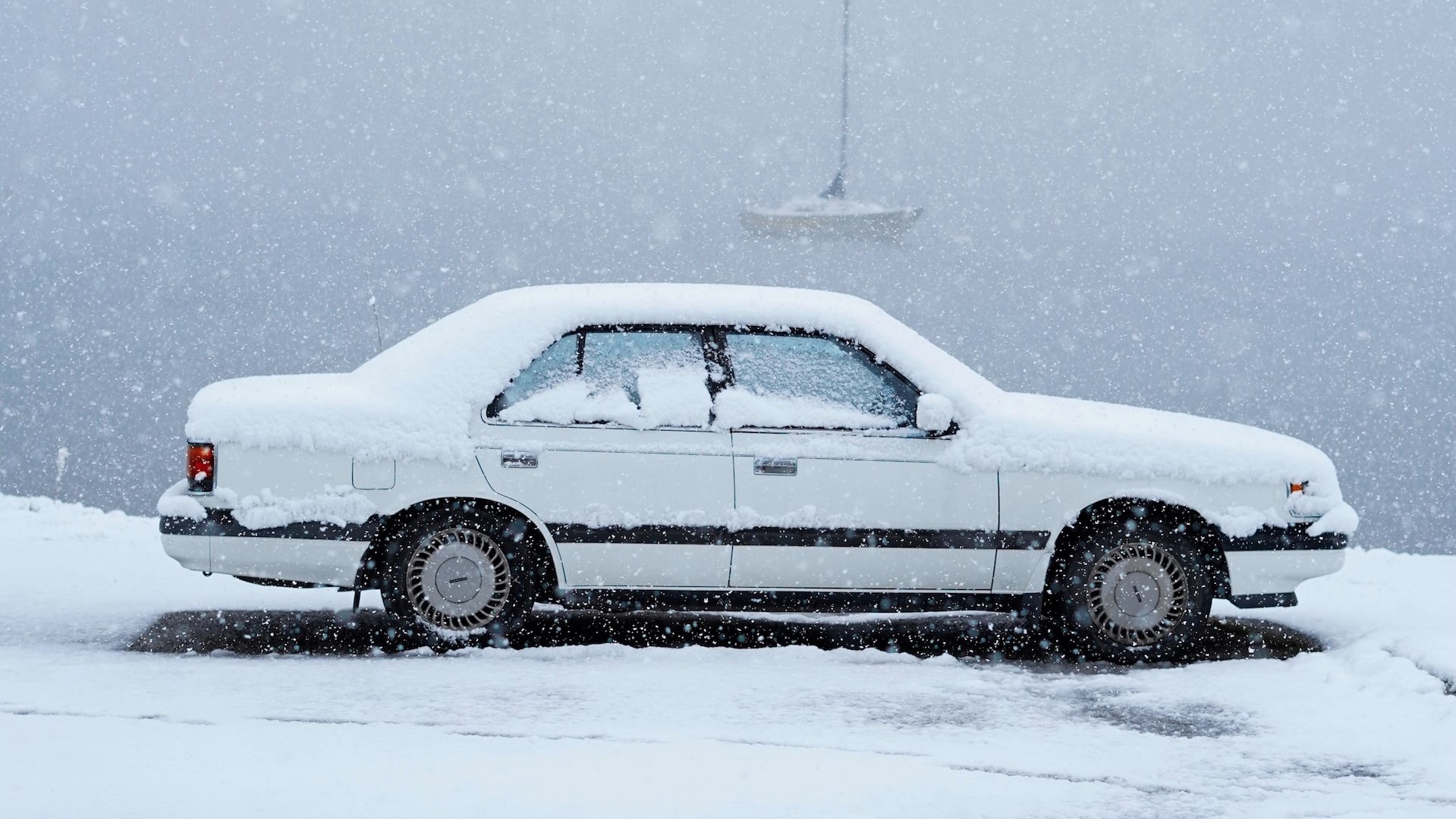 White car covered in snow | Kids Car Donations