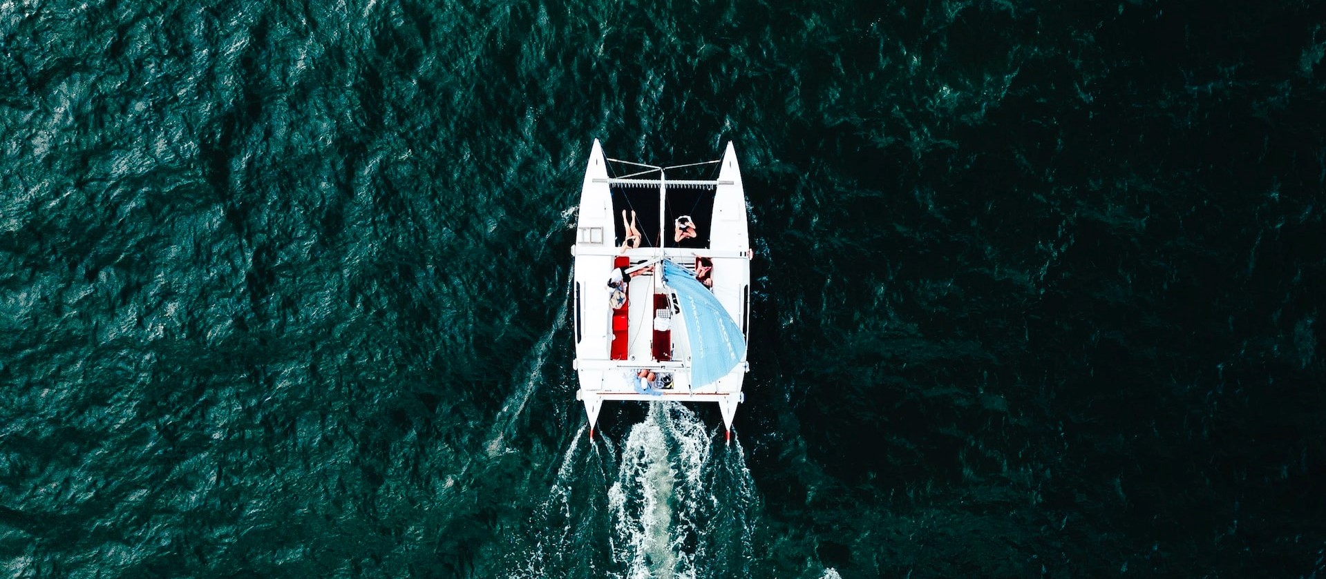 Aerial view of a whtie catamaran on the ocean | Kids Car Donations
