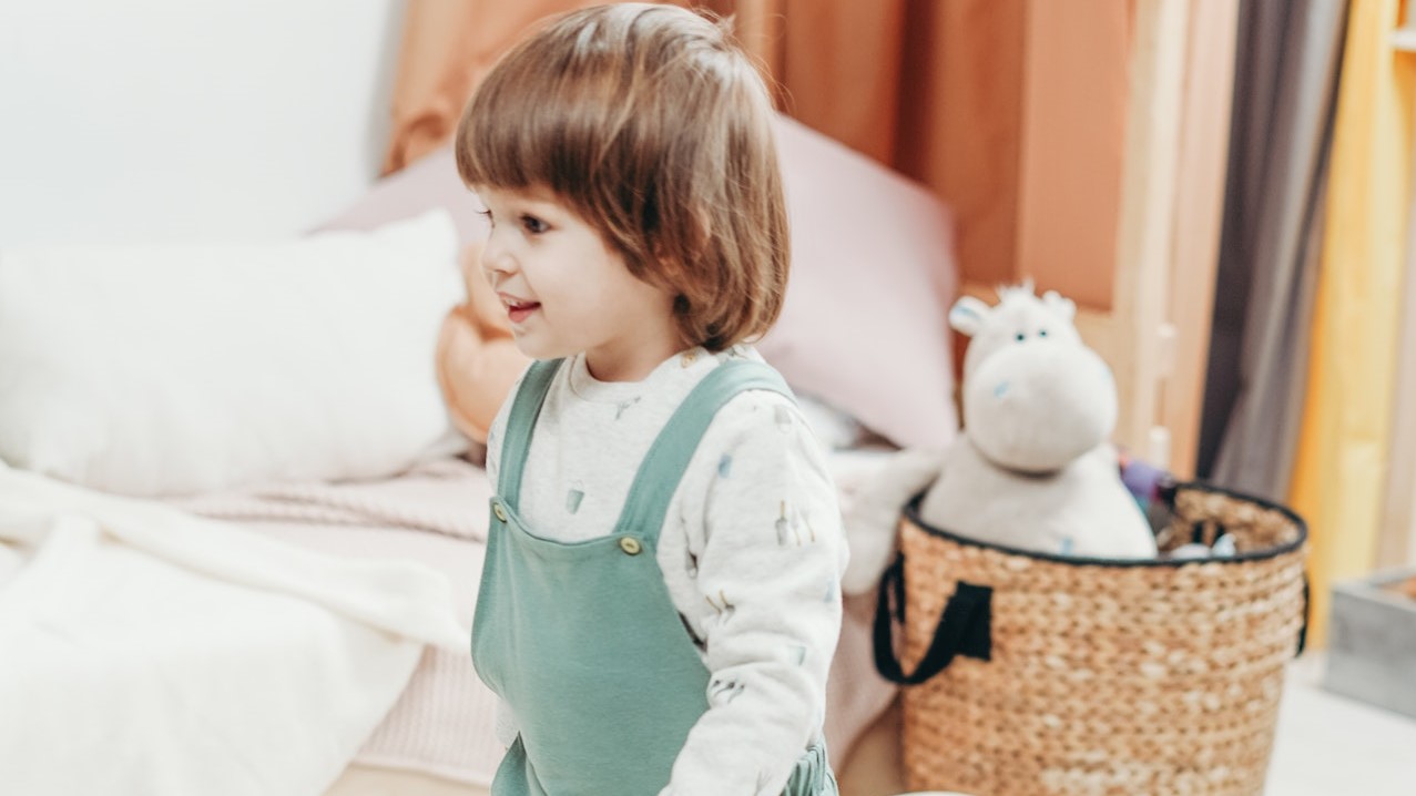 Child in White Long-sleeve Top and Green Dungaree Trousers Playing With Wooden Toy | Kids Car Donations