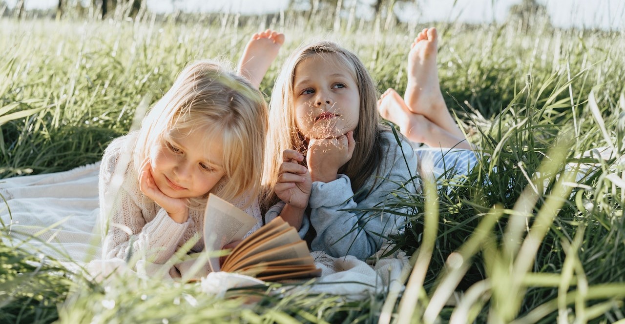 Little Girls Lying on Green Grass Field | Kids Car Donations