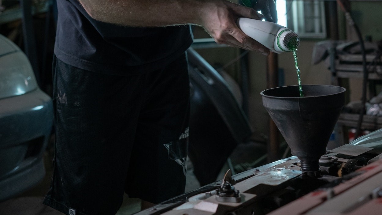 Man adding coolant on radiator | Kids Car Donations