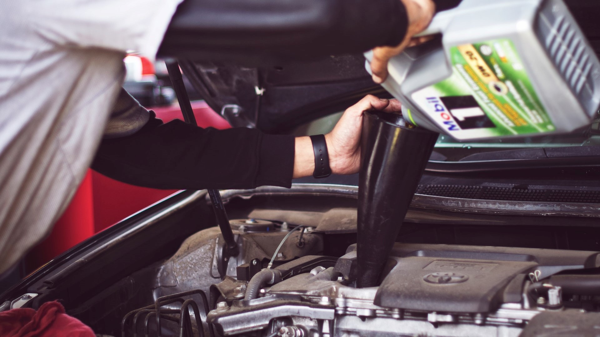 Man adding motor oil on a car engine | Kids Car Donations