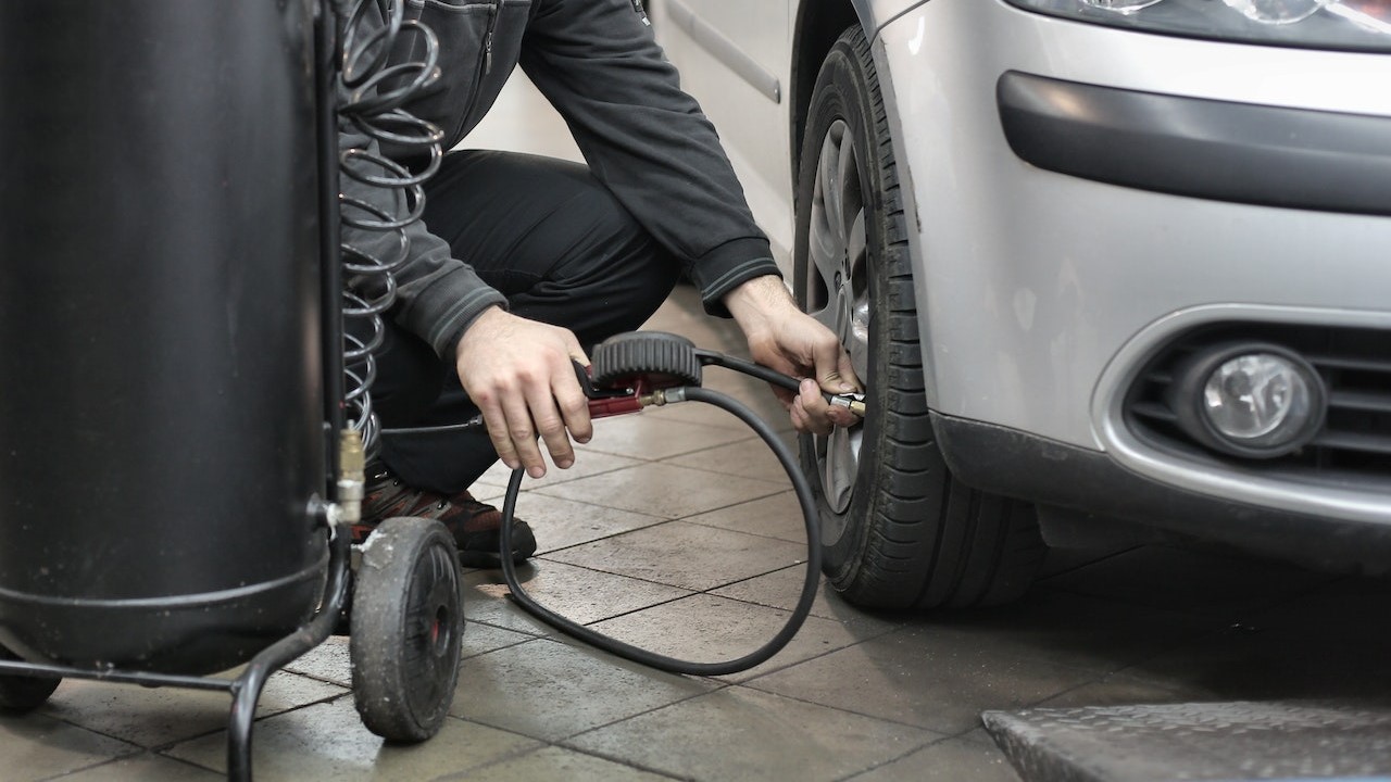 Man checking tire air in his car | Kids Car Donations