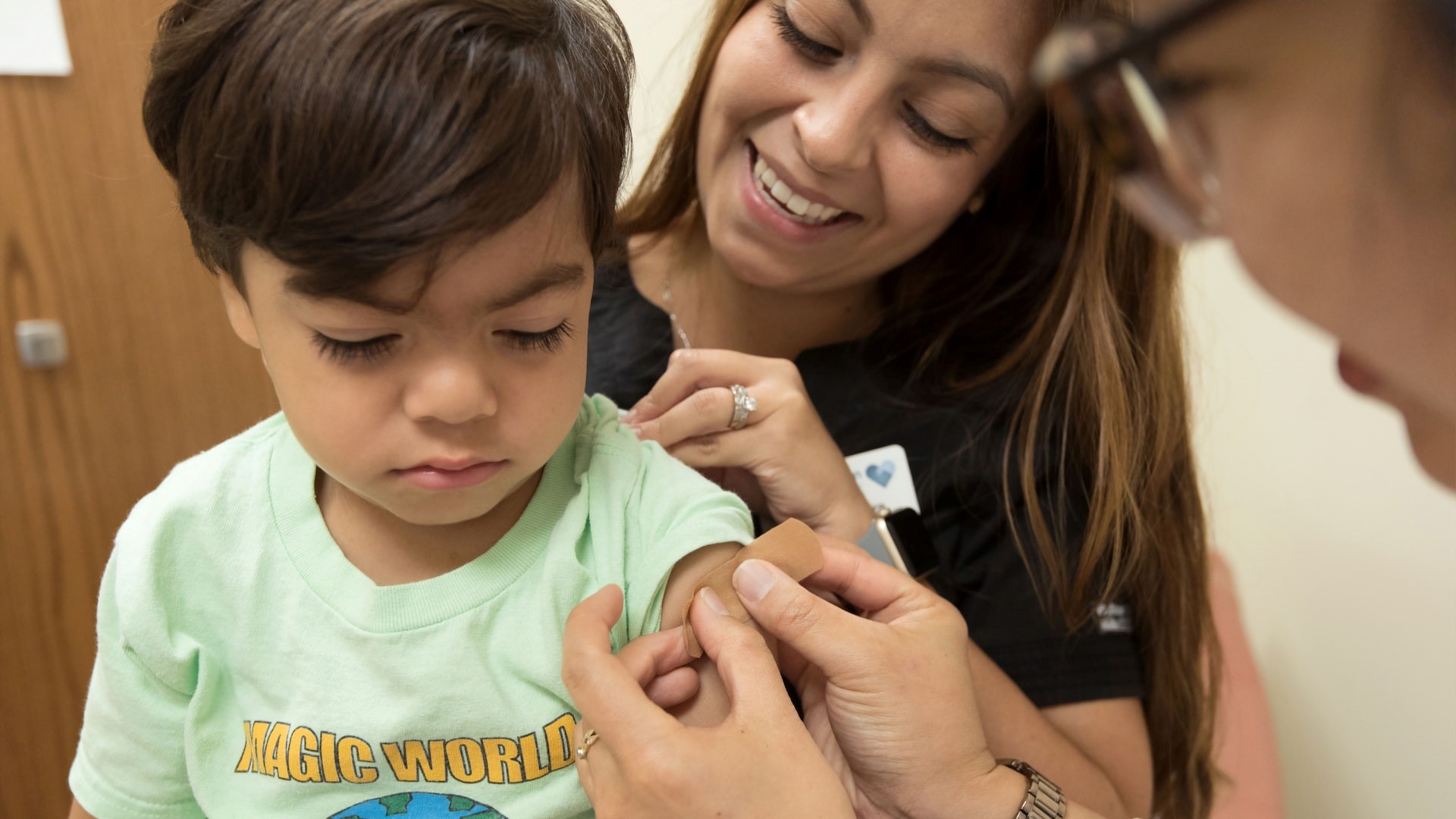 Nurse putting bondaid on kid shoulder | Kids Car Donations