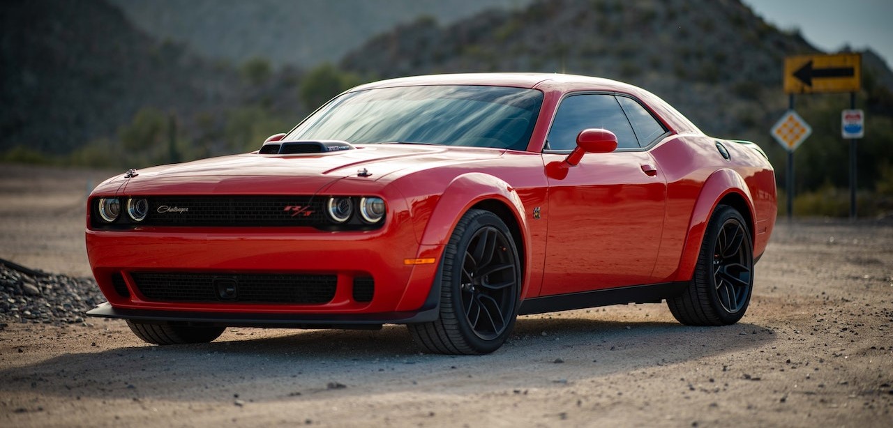Red Dodge Challenger Parked on Unpaved Road | Kids Car Donations
