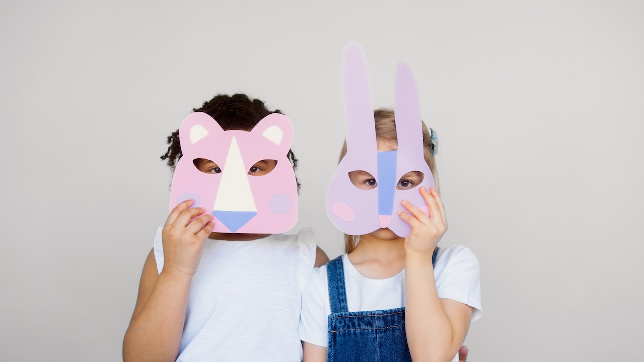 Two Kids Covering Their Faces With a Cutout Animal Mask | Kids Car Donations
