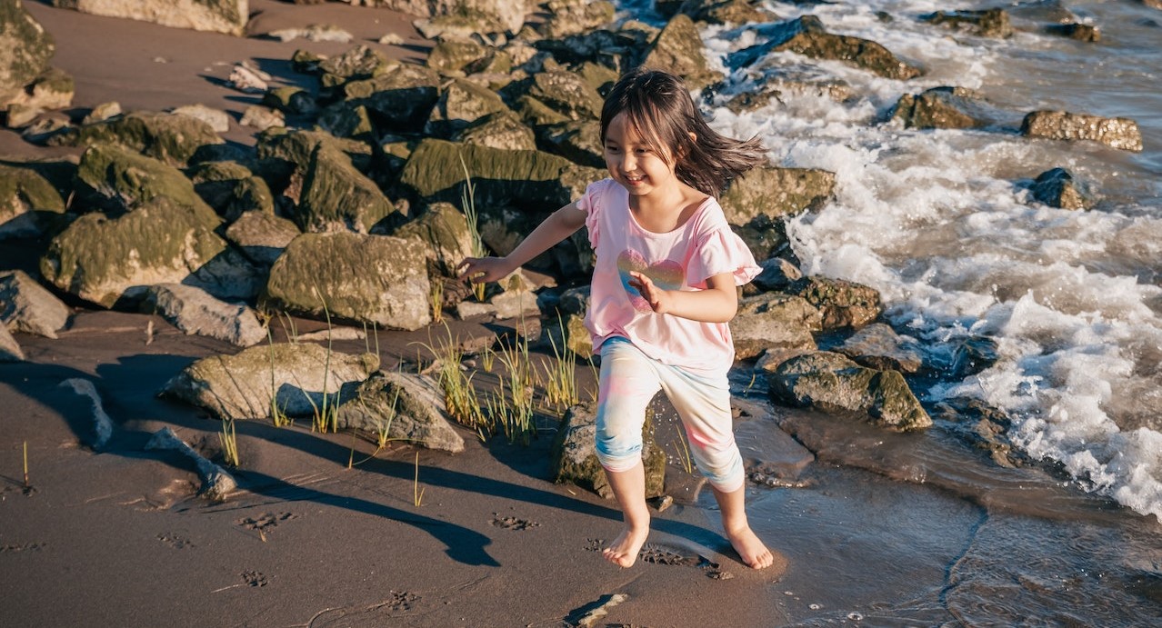Young Girl Running on a Rocky Shore | Kids Car Donations
