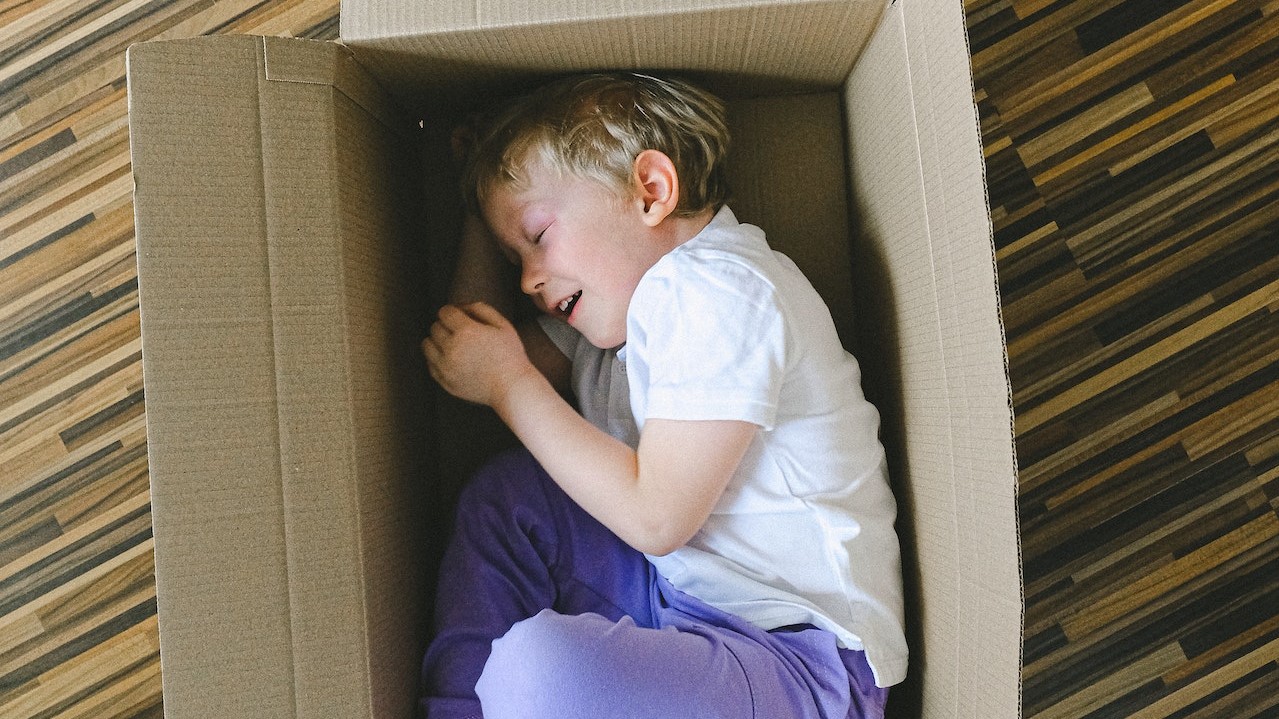 Boy In White T-shirt Inside A Box