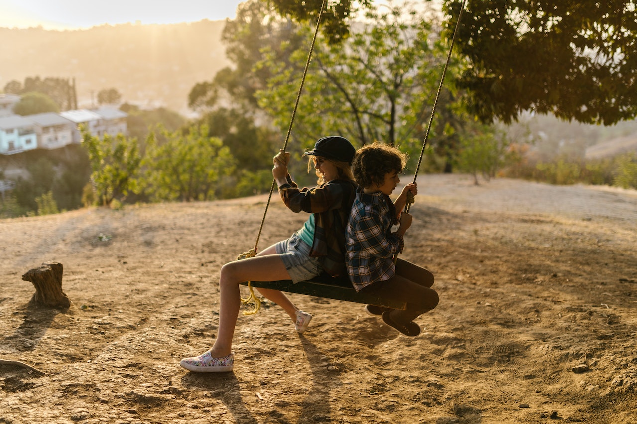 Girl and Boy in Plaid Shirts Sitting on a Swing | Kids Car Donations