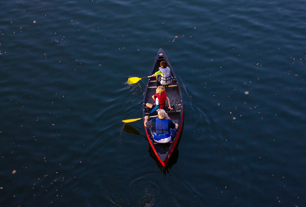 People Riding Red Canoe Boat | Kids Car Donations