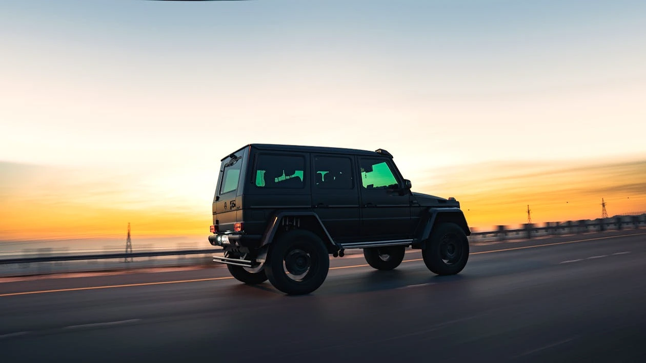 4×4 SUV driving along a sunset road