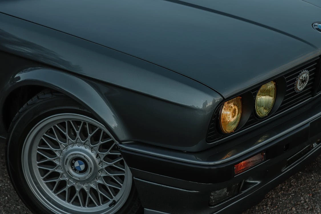 A black car with headlights illuminated in a close-up automotive shot