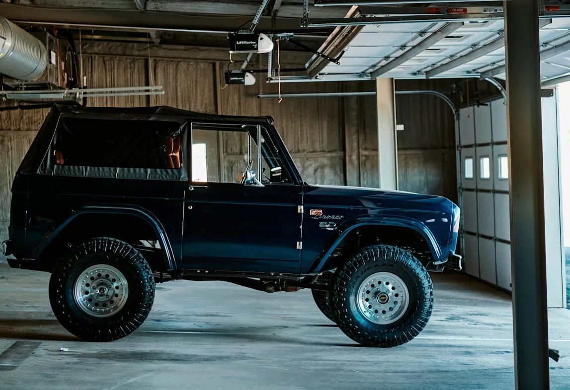 Blue Ford Bronco parked inside a garage