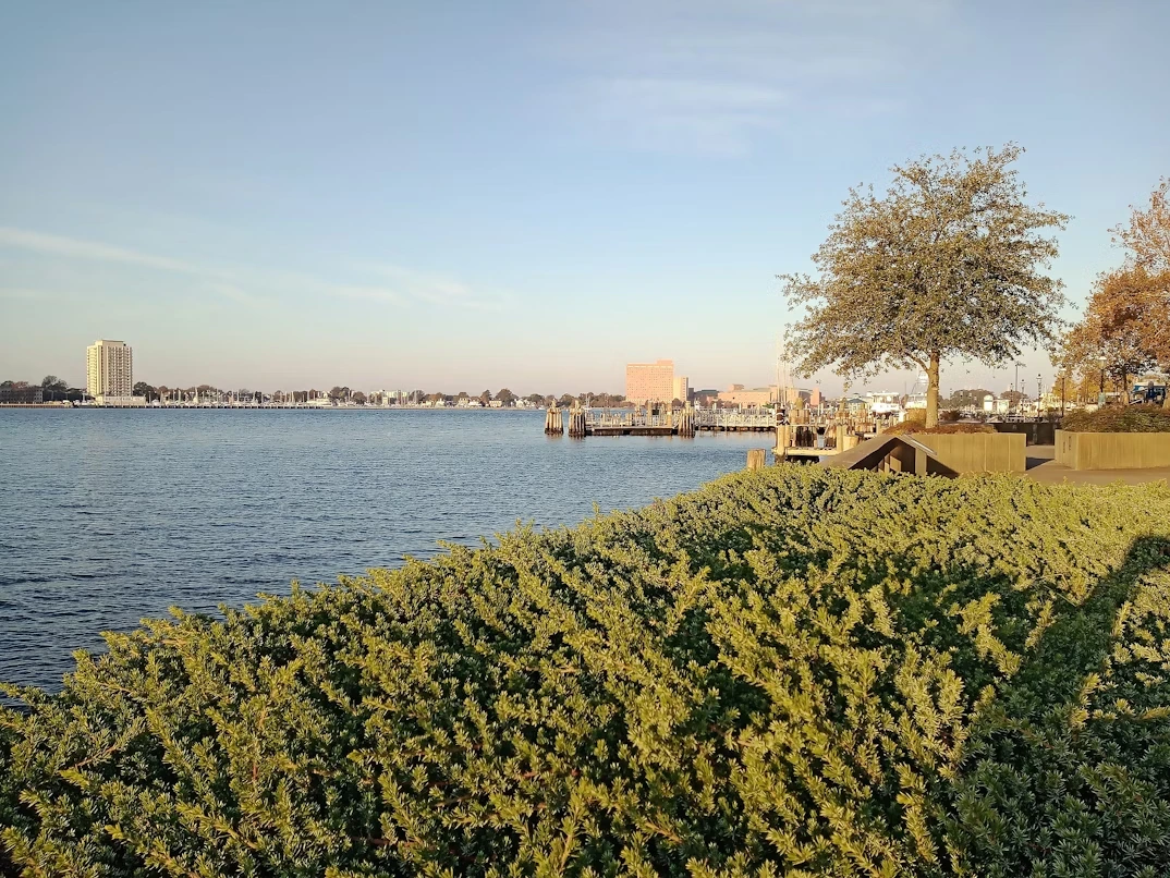 Body of water in Norfolk with a bridge in the background at sunset
