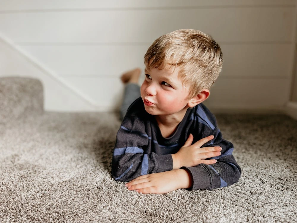 A boy lying on the floor indoors