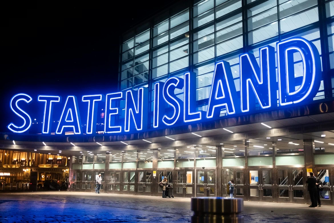 A building with a neon sign that reads “State Island” on a street in Staten Island, NY