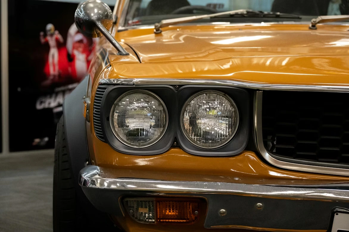 Close-up of the front of a yellow Mazda RX-3 in Hampton Downs, New Zealand
