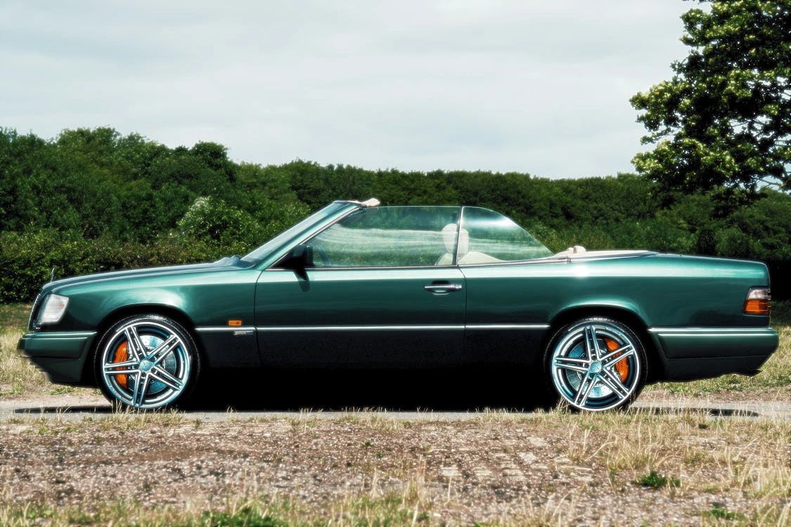 Green convertible car parked on a grassy field
