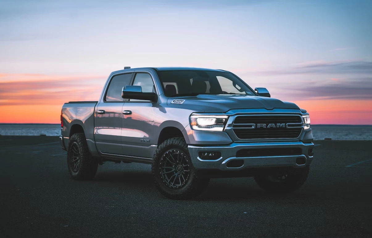 A silver Ram pickup truck parked in a parking lot at sunset in Long Island, New York