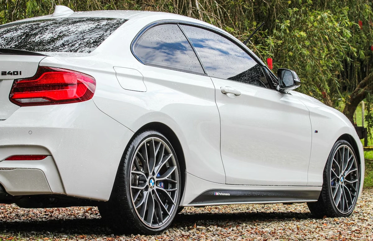 White BMW car parked on a gravel road