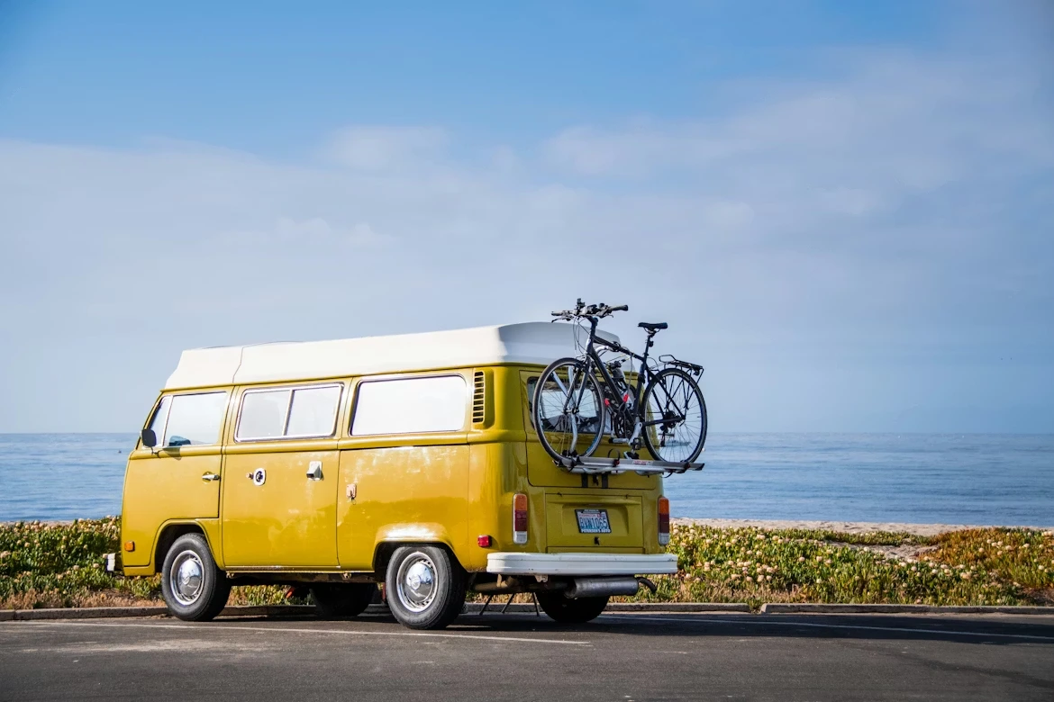 A yellow van with a bike on top of it