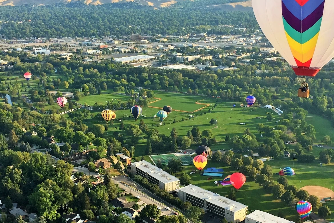 Aerial view of green grass field with hot air balloons in Boise, Idaho