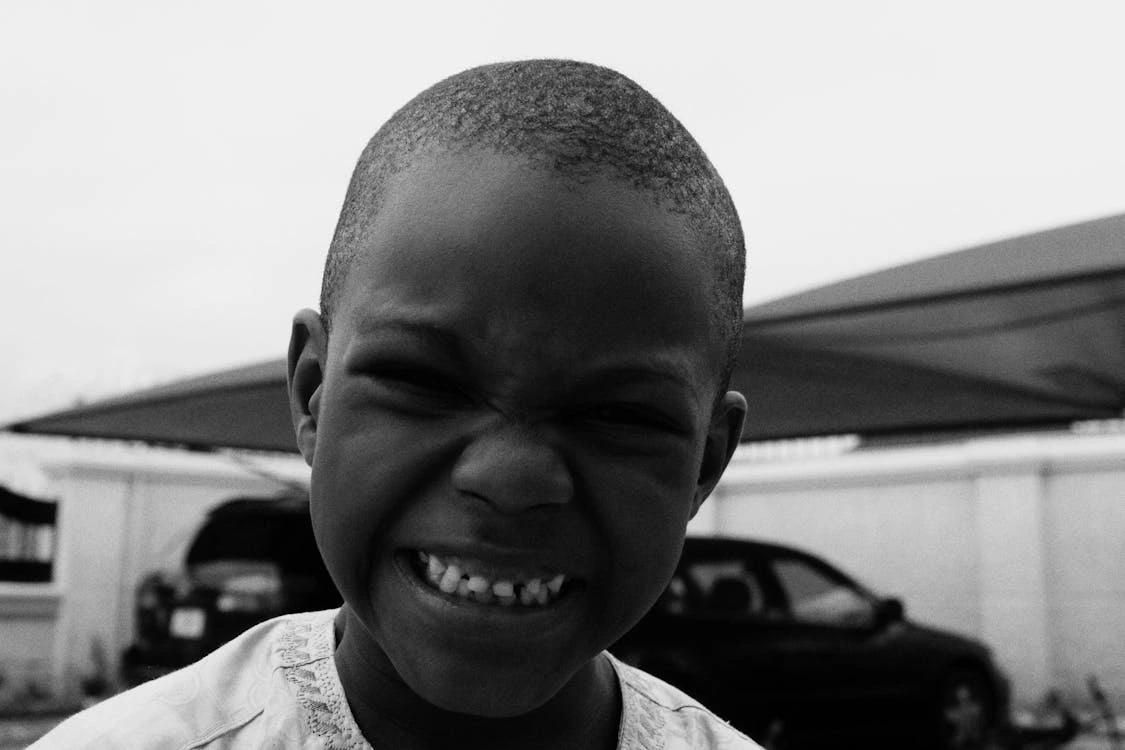 Black and white photo of a smiling boy outdoors