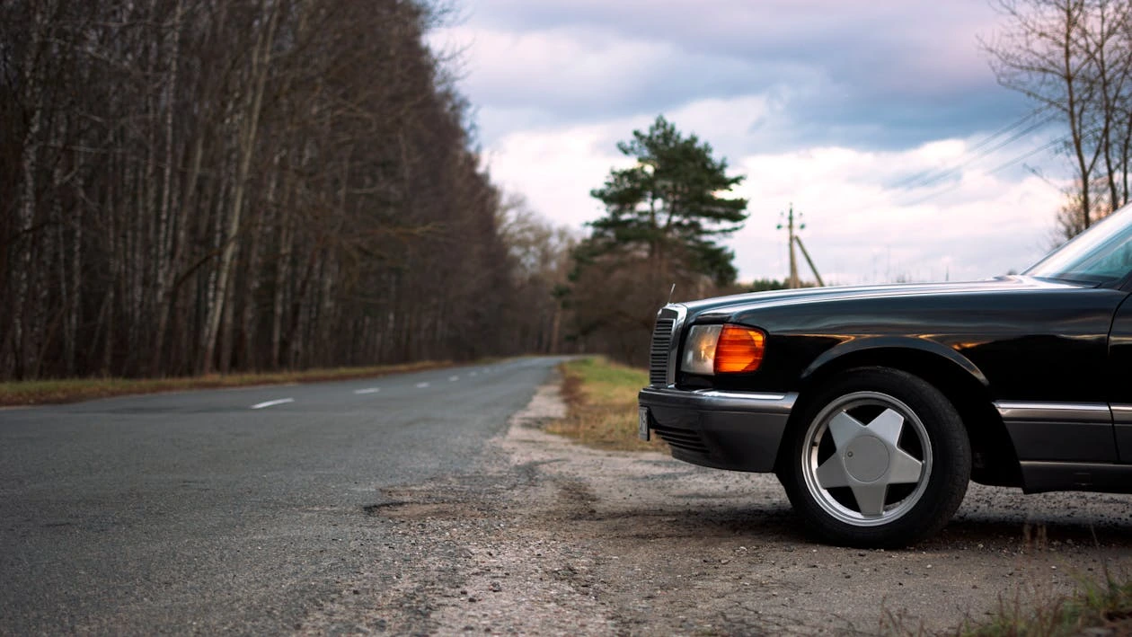 Black Mercedes parked near a road surrounded
