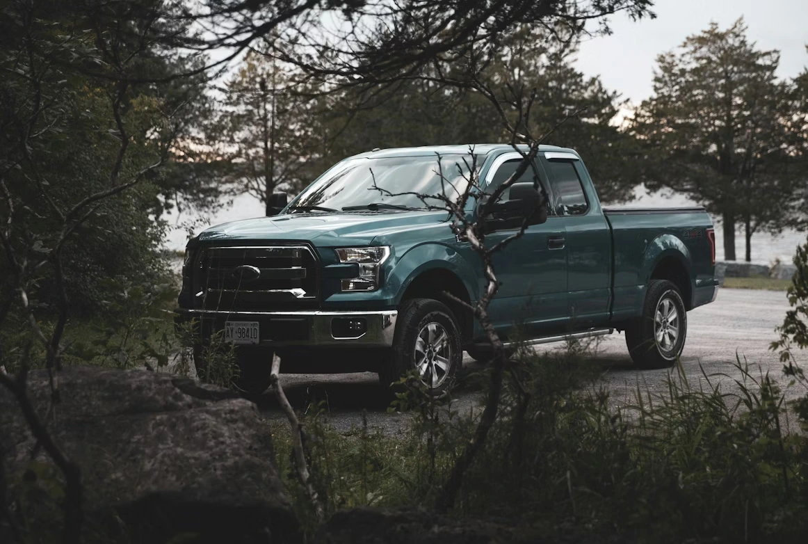 Blue Chevrolet Crew Cab pickup truck parked near trees during daytime