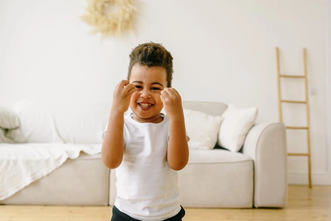 oy in white shirt smiling indoors